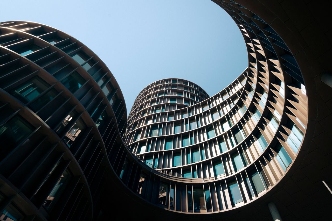 The Art of Drawing Readers In: Your attractive post title goes here Curved modern building facade against a clear blue sky in Copenhagen.